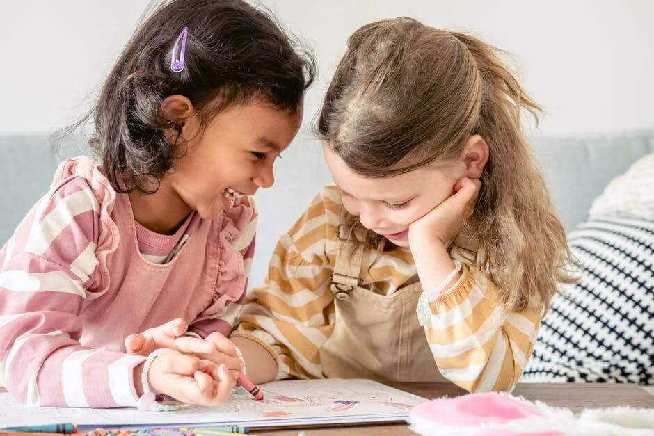two kids coloring and laughing